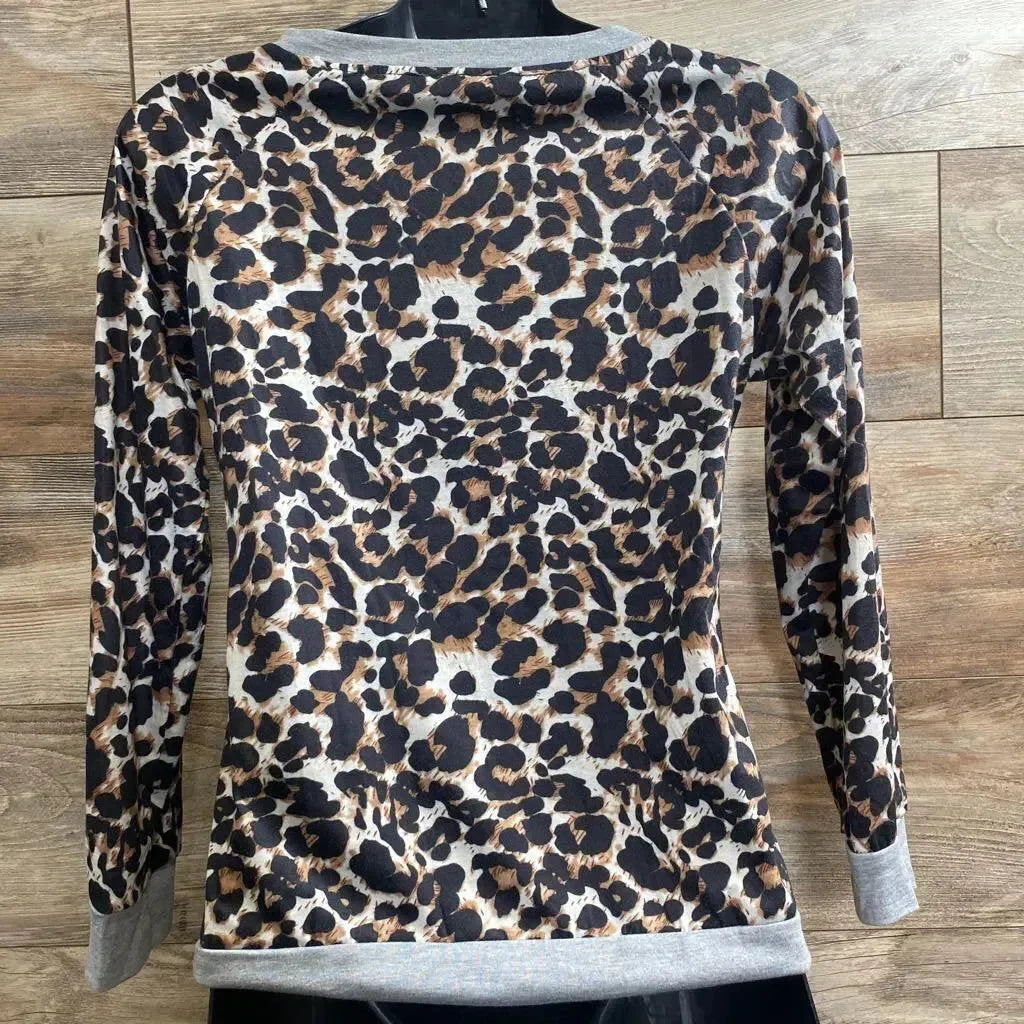 Rear view of leopard-print nursing shirt size M showing long sleeves and gray cuffs on a mannequin against wood floor