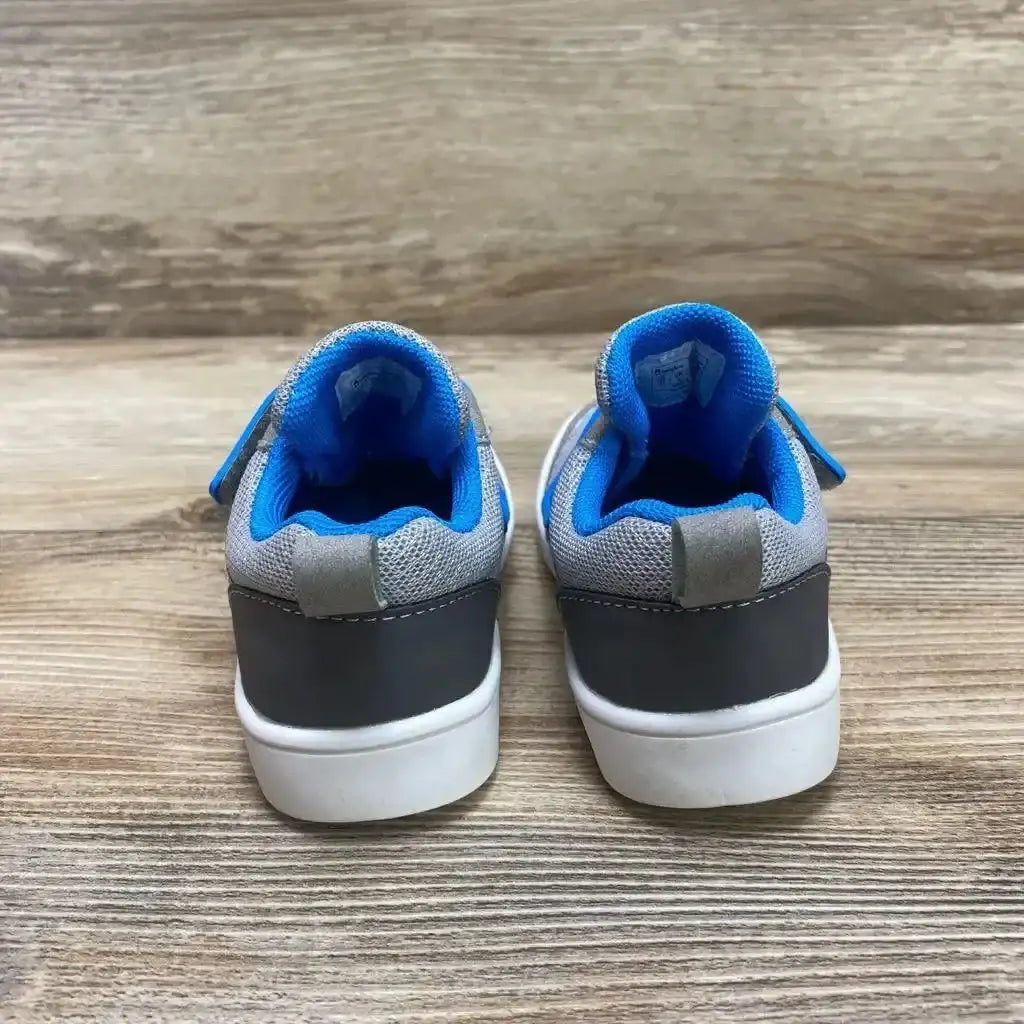 Back view of toddler gray Oomphies Devon sneakers size 7C showing blue padded collar, velcro strap, and white soles on wood floor