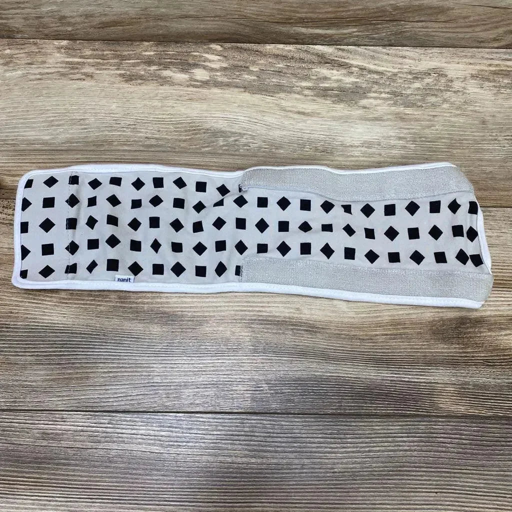 Top-down view of Nanit breathing band wrap showcasing black square pattern and Velcro fastening on wooden floor background