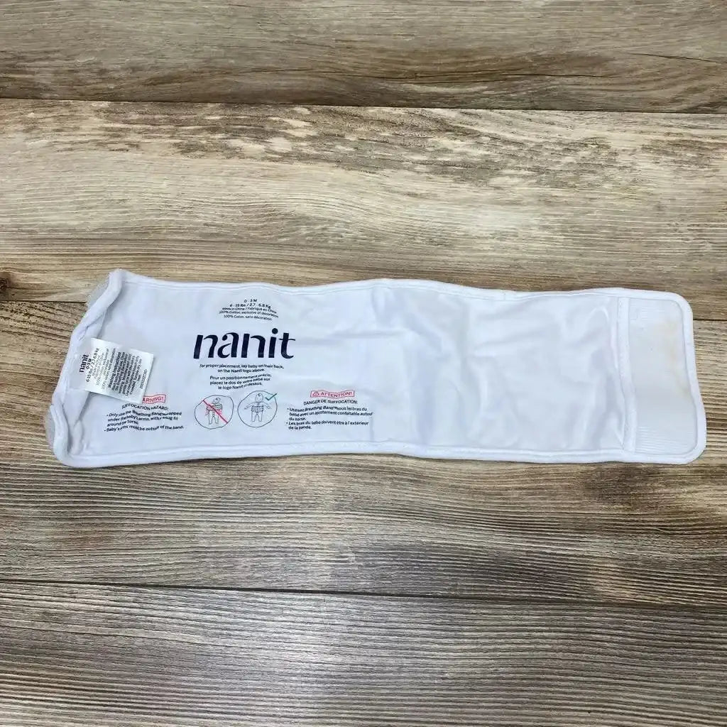 Flat lay of Nanit breathing band wrap size 0-3 months showing Velcro closure and printed Nanit logo on wood background