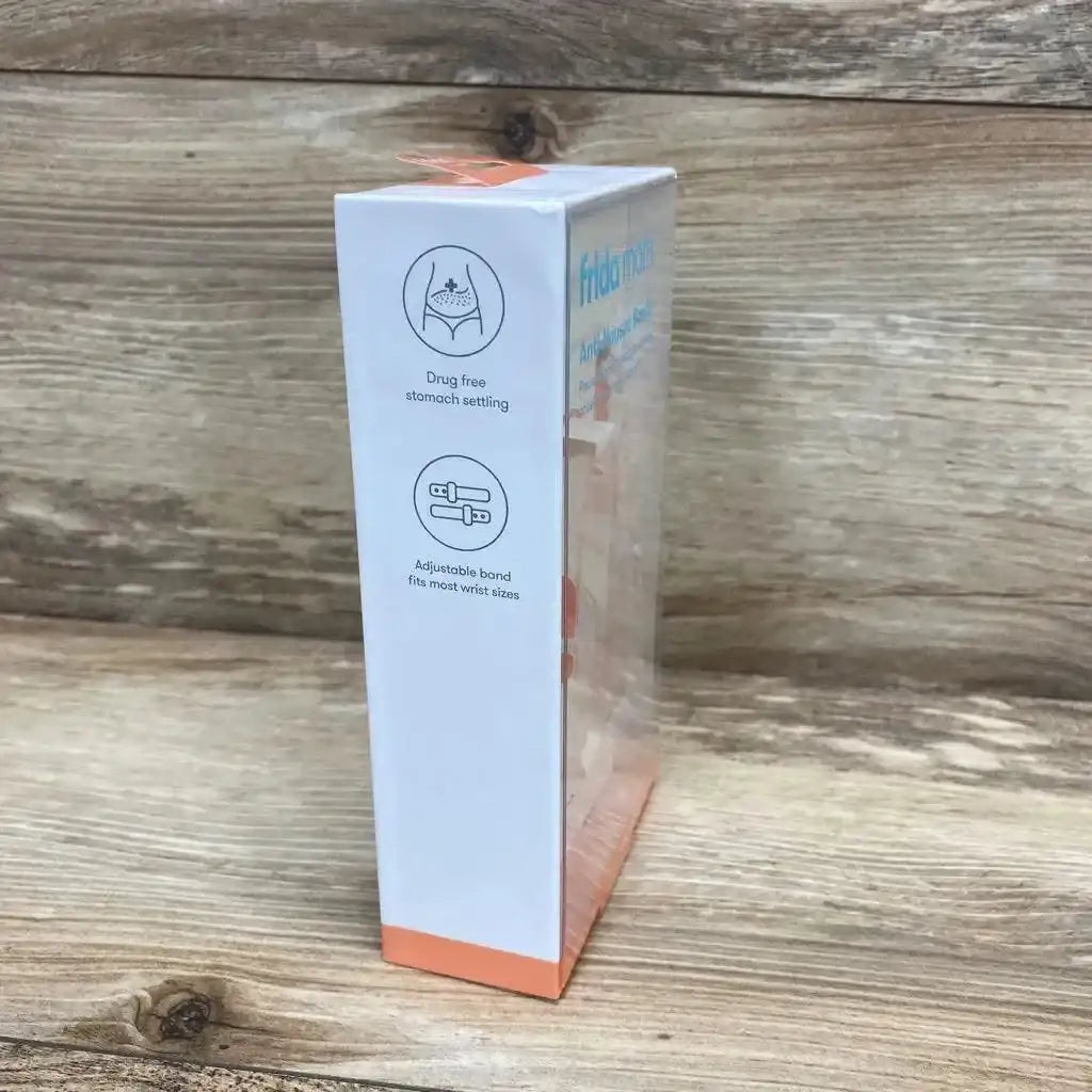 Side view of Frida Mom Anti-Nausea Bands box showing icons for drug-free relief and adjustable band on wooden background