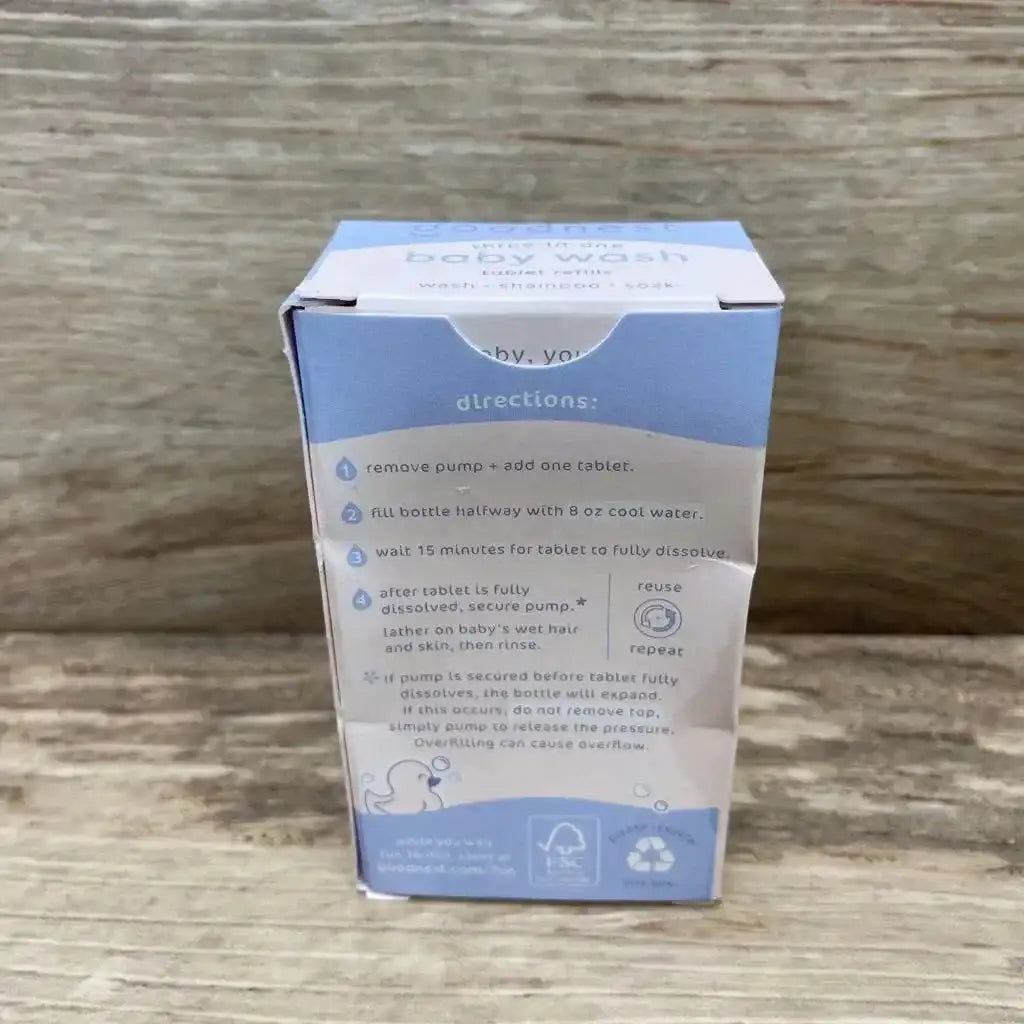 Back view of Goodnest three in one baby wash tablet refills box showcasing blue directions panel and FSC recycle marks on wood plank background