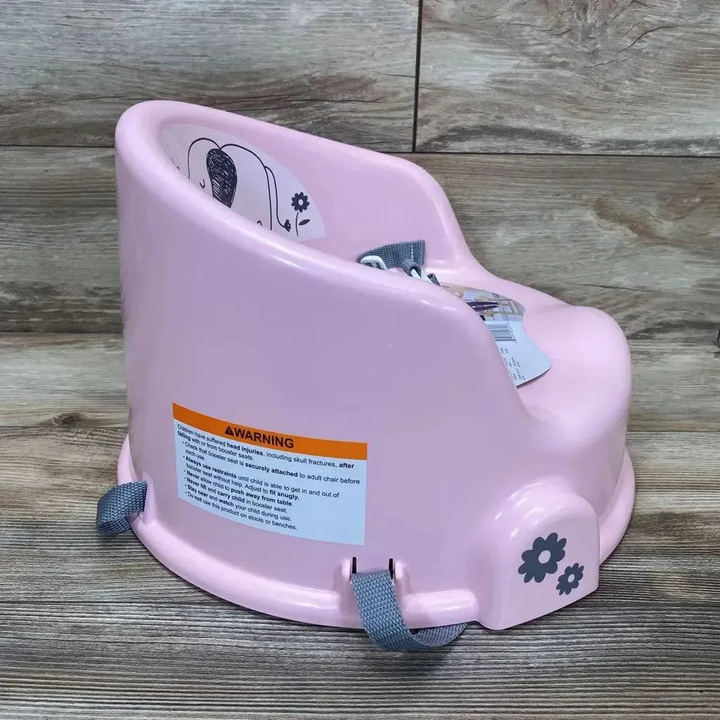 Side view of pink DreamGro elephant booster seat showing gray safety straps, molded high back with elephant decal and flower decal on wood floor