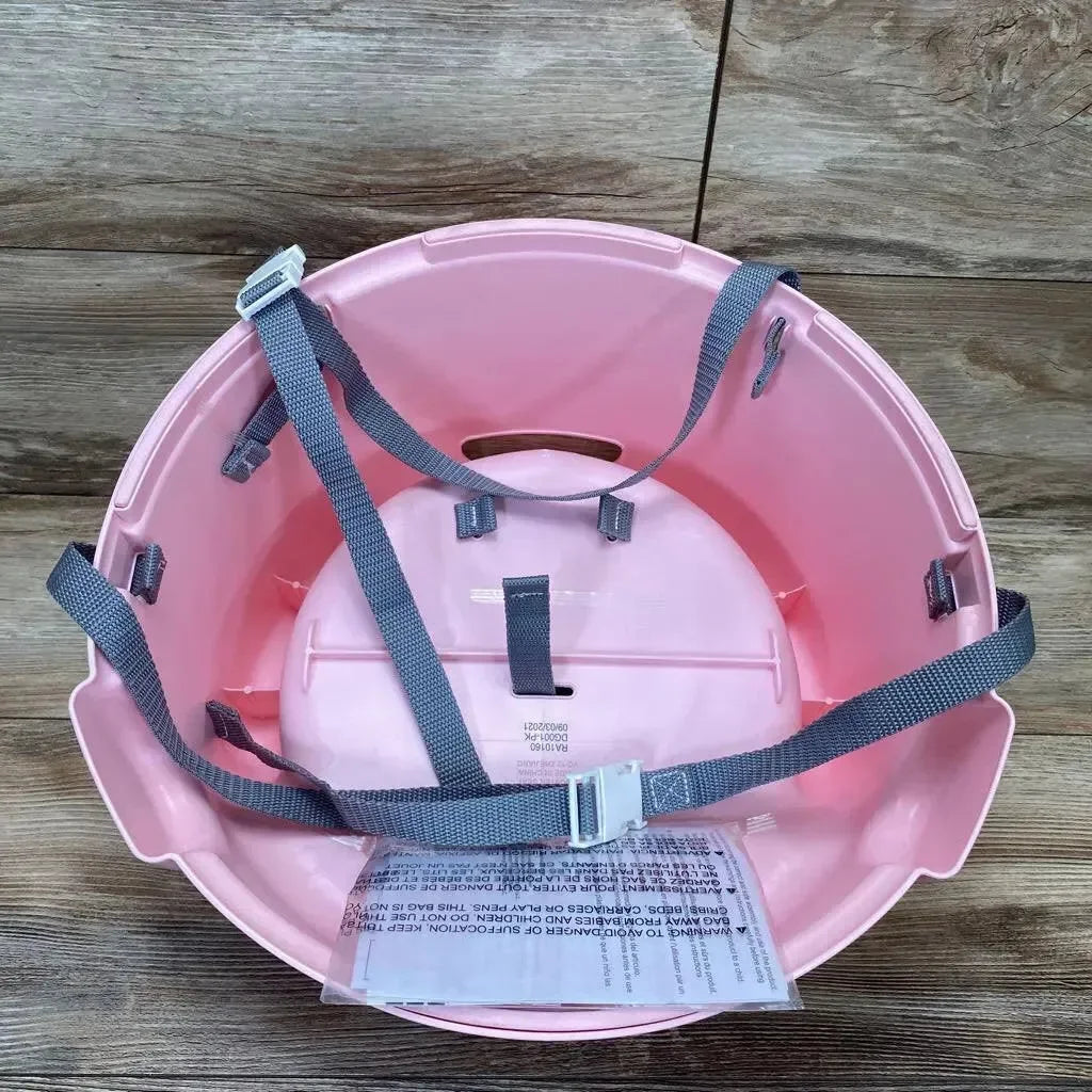 Top-down view of pink DreamGro Elephant booster seat showing gray adjustable harness straps on wood floor background