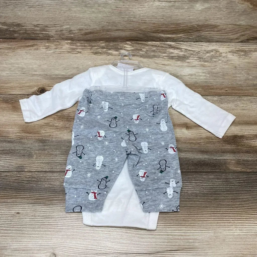 Top-down view of 2-piece baby bodysuit set: white long-sleeve bodysuit with grey snowman-print pants on wood background