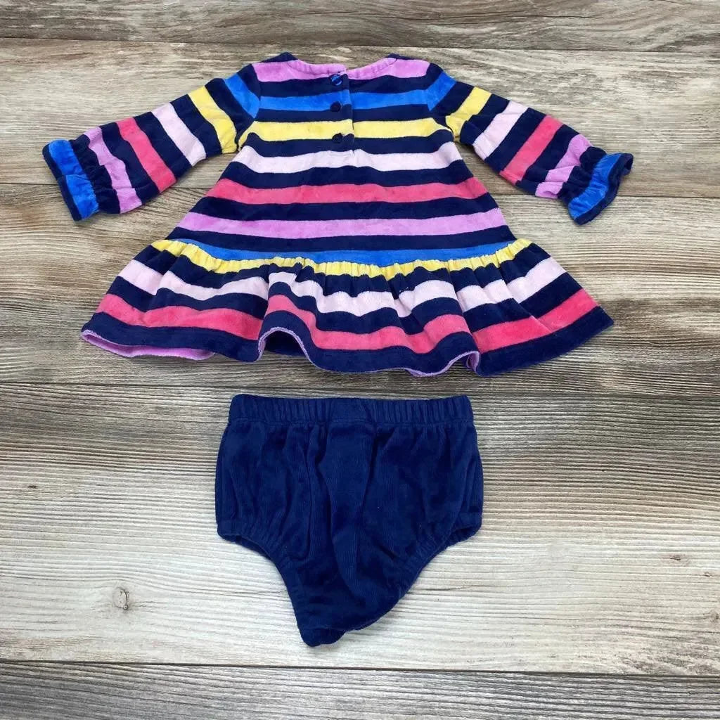 Flat lay of baby striped dress and navy bloomers showing ruffled hem, cuffed sleeves and back buttons on wood background