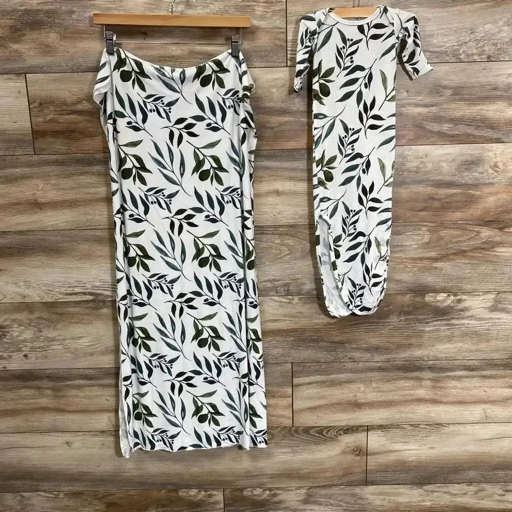 Front view of Milkmaid Goods Oliver swaddle and knotted gown set showcasing a leafy botanical print on a wood backdrop