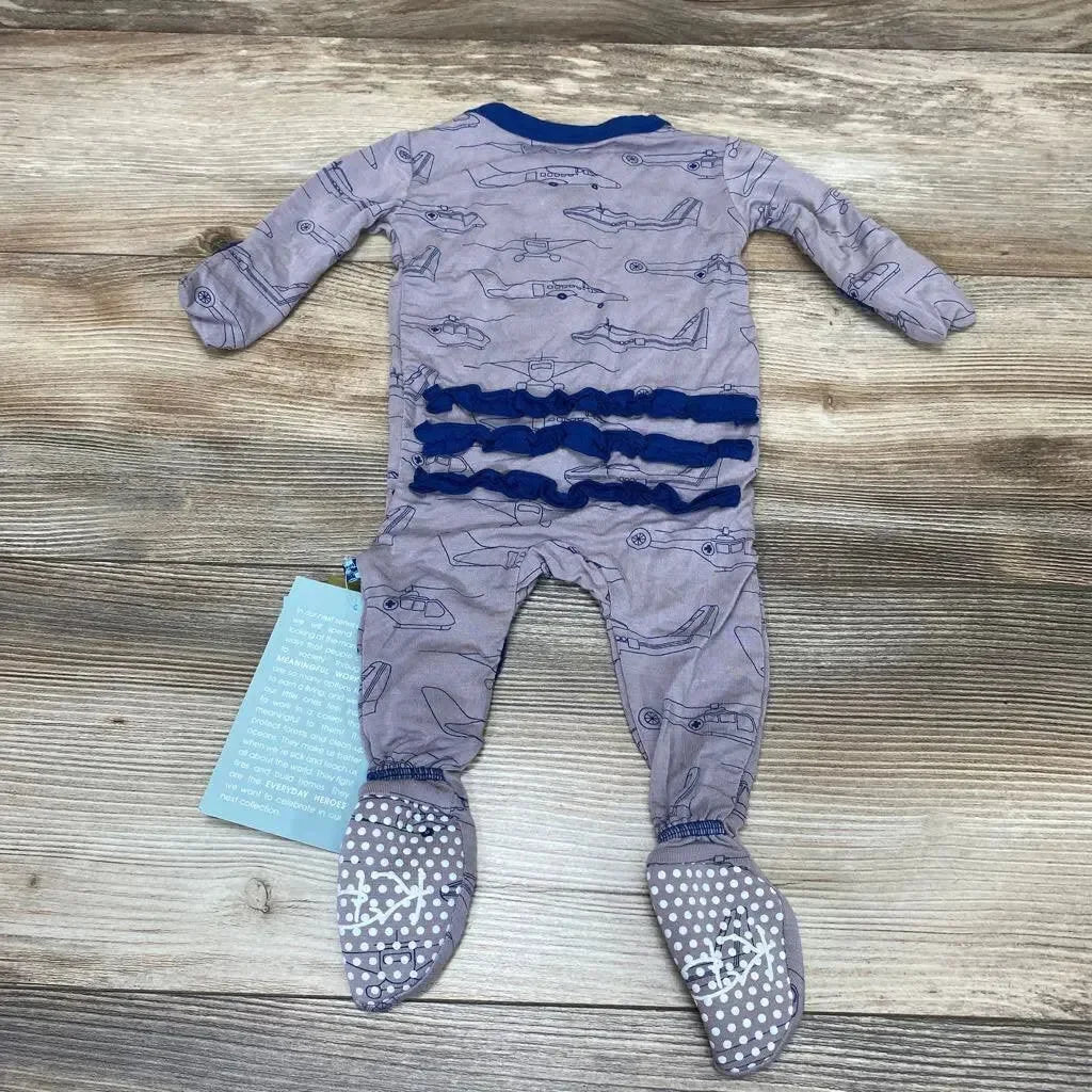 Back view of Kickee Pants ruffle snap footie showcasing three navy ruffle rows and airplane print with dotted non-slip soles on wood background