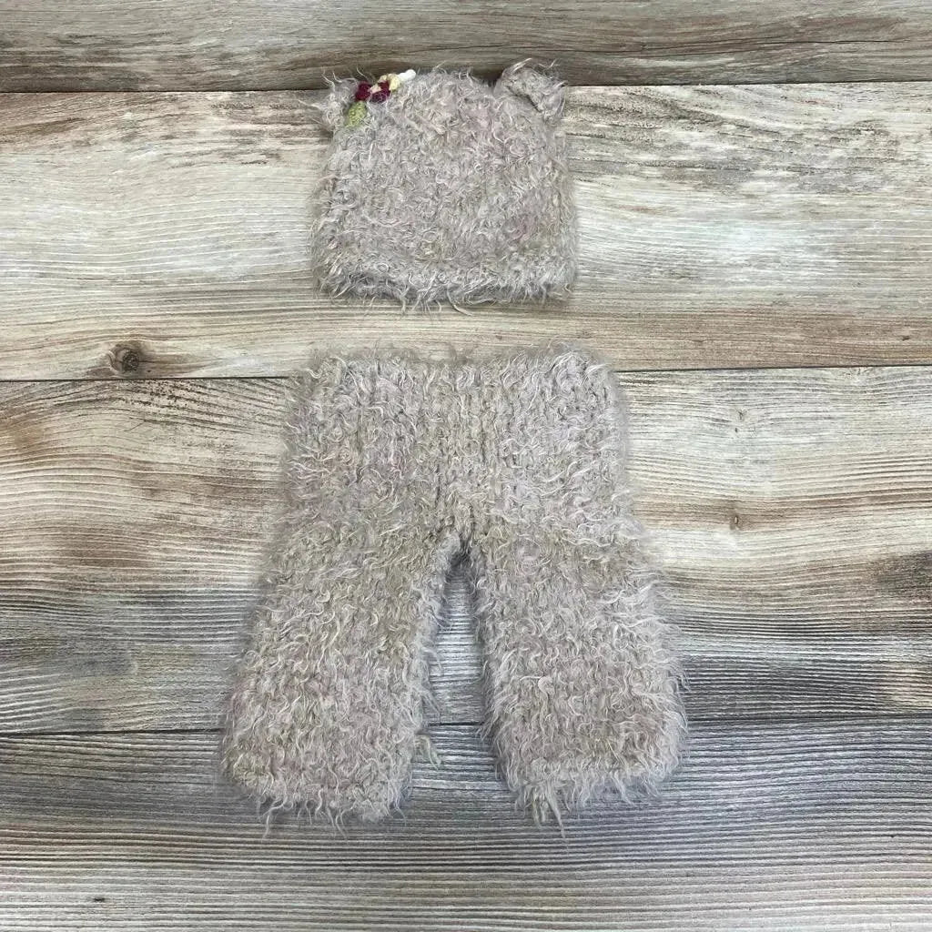 Top view of Bear Hat And Pants Set showcasing gray curly textured fabric and bear ear hat on a wood grain background