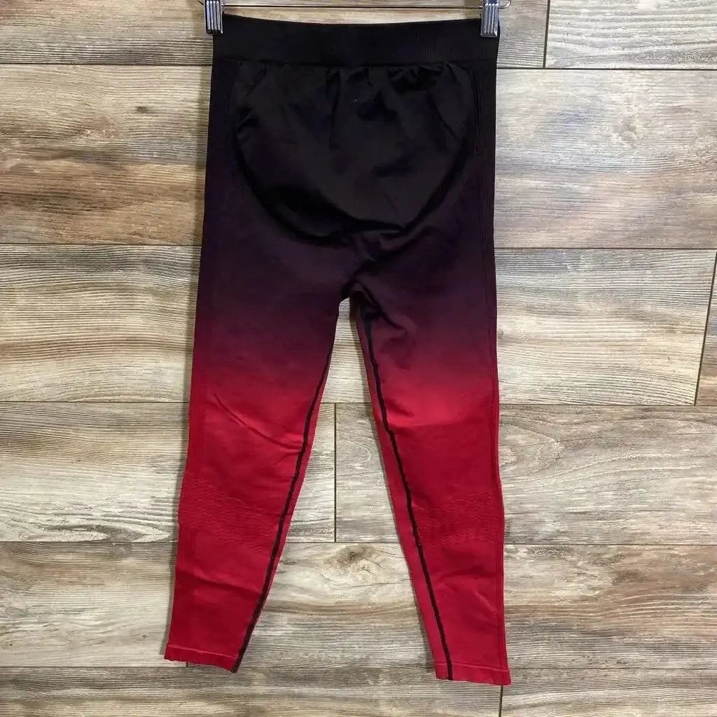 Front view of maternity leggings showcasing high belly-support panel and ombre red-to-black color on wood floor background