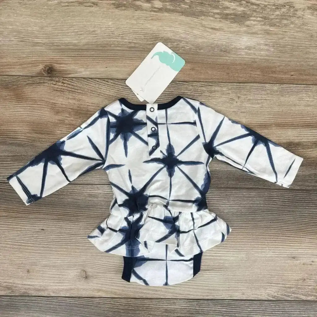 Flat lay of NEW Monica and Andy Shibori Dress Bodysuit sz 0-3m showcasing navy and white star tie-dye print with peplum and hangtag on wood plank floor