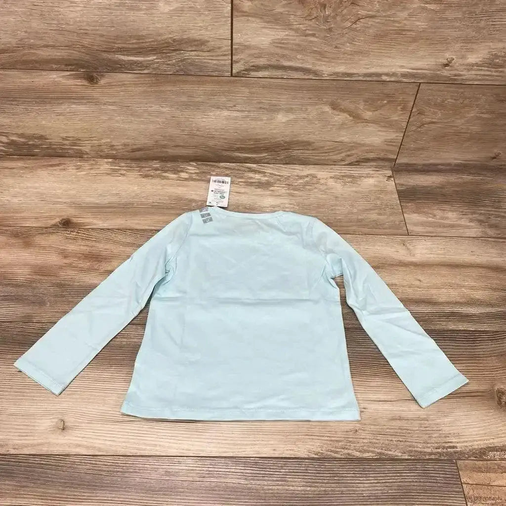 Back view of NEW Carter’s Hugs Shirt size 3T showing long sleeves and light blue fabric on a wood floor