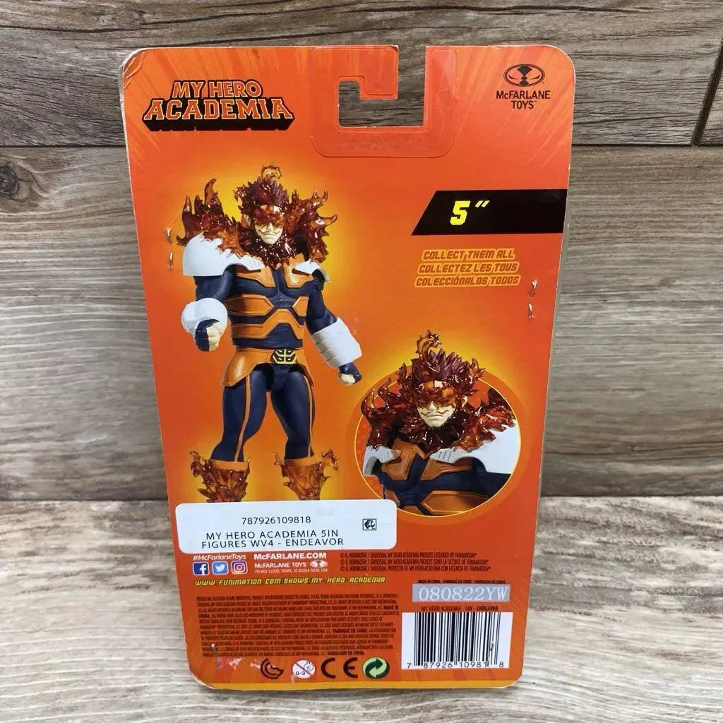 Rear view of Endeavor 5-inch action figure in packaging showing flame effects and character art on orange card with wood background