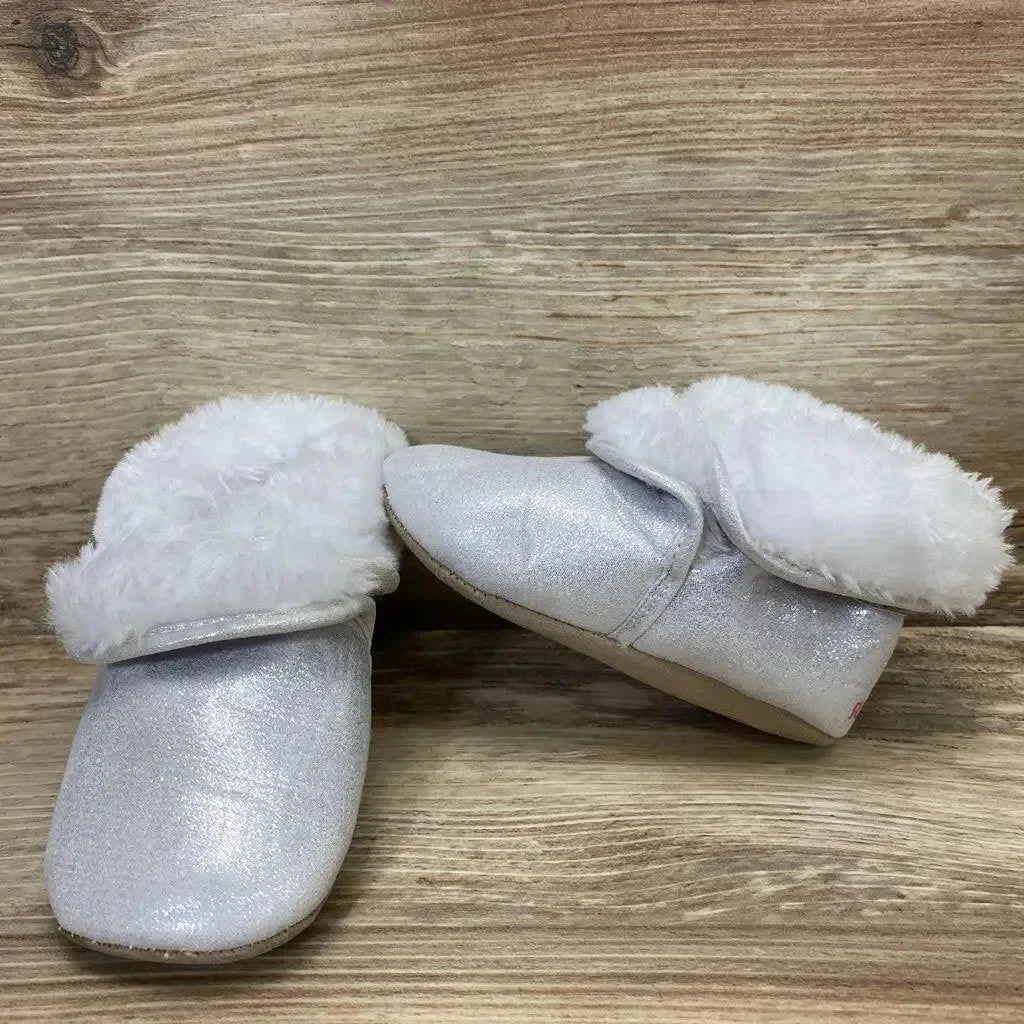 Three-quarter view of silver toddler booties size 4C with fold-over white faux-fur cuff and glitter finish on wood backdrop