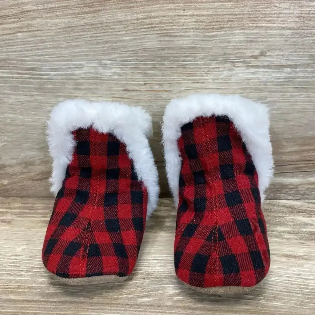 Front view of Robeez Jack soft sole baby boots showcasing red and black plaid with white faux fur cuff on wood background