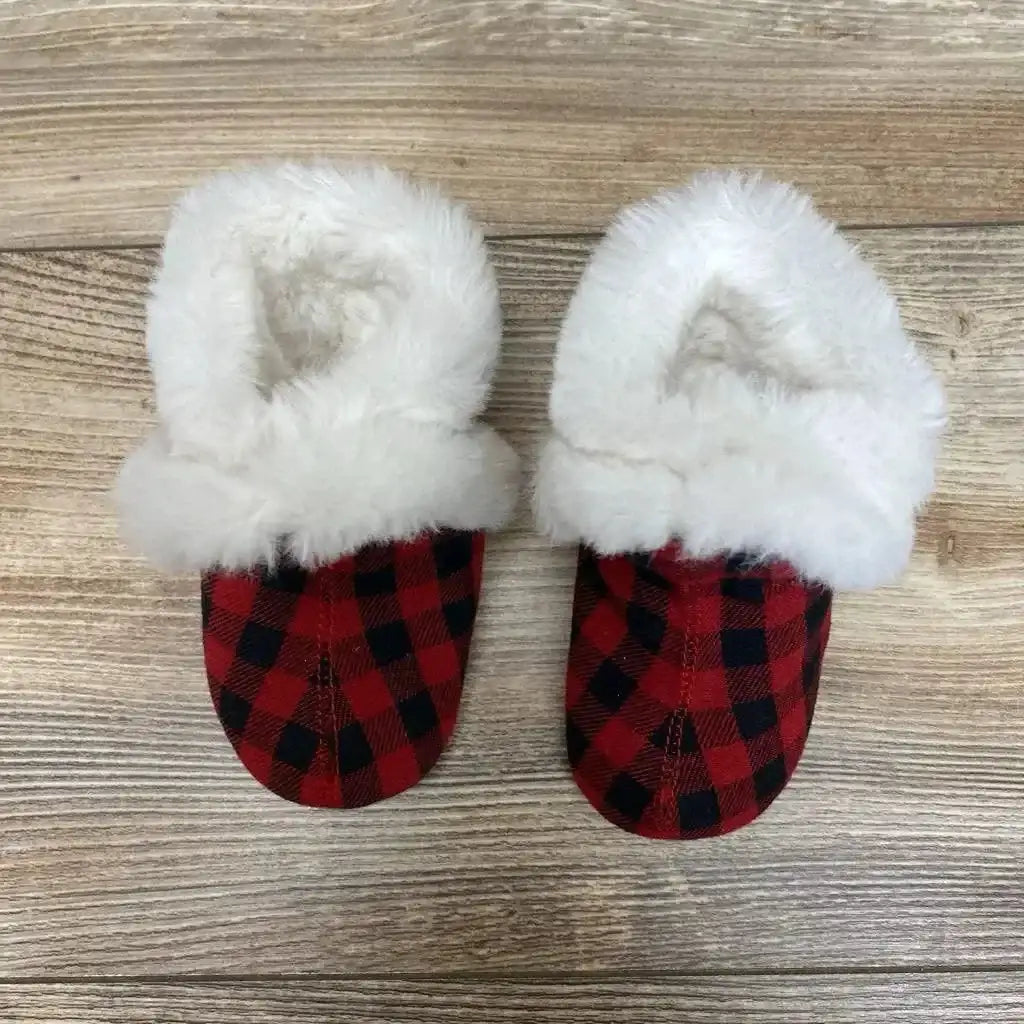 Top-down view of Robeez soft sole baby boots showcasing red and black plaid fabric and white faux fur cuffs on a light wood background