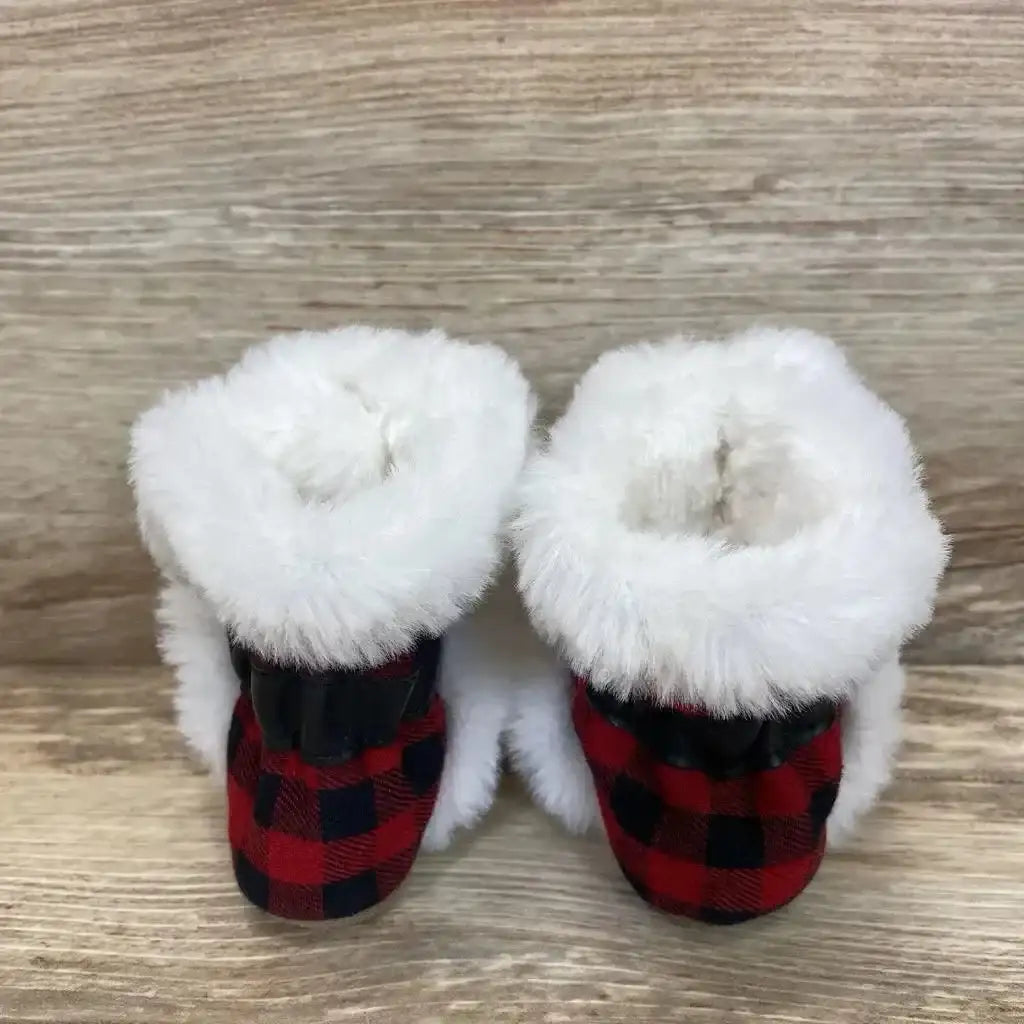 Front view of Robeez soft-sole baby boots, red buffalo plaid with plush white faux-fur cuffs, elastic heel, on wood background