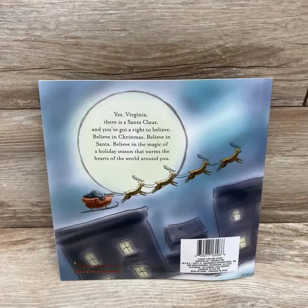 Back cover of Yes, Virginia, There Is a Santa Claus paperback book showing Santa’s sleigh and reindeer above rooftops