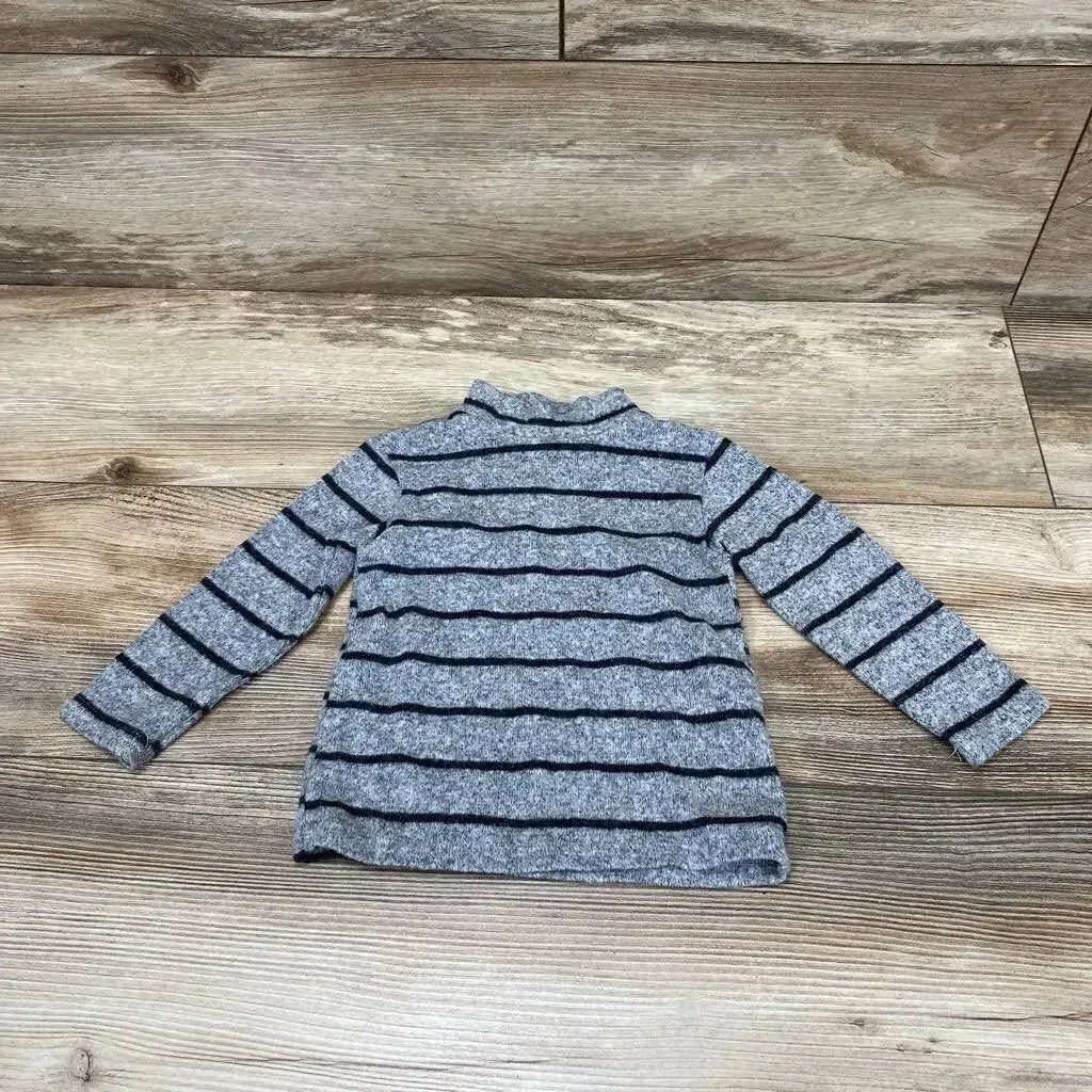 Flat lay of Zara striped shirt in heather grey with navy stripes and mock neck long sleeves on wood plank background