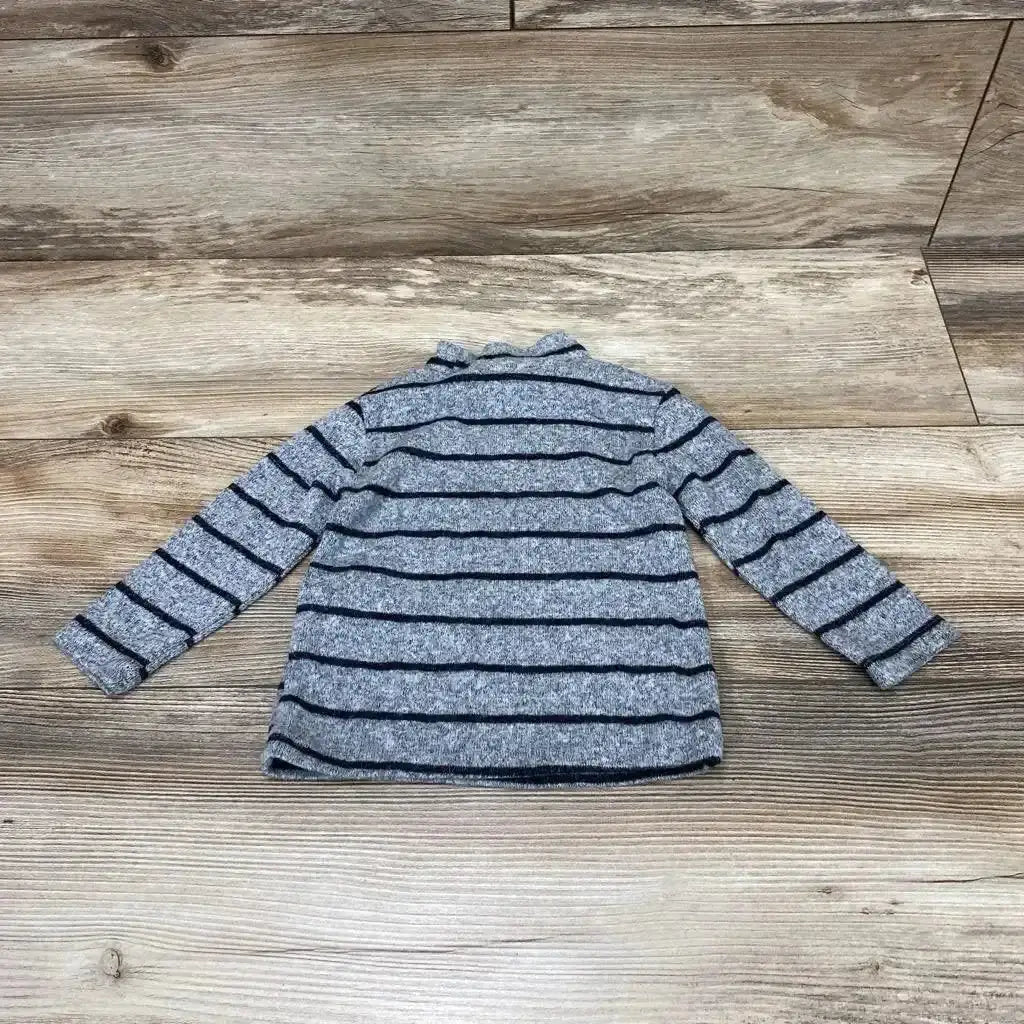 Flat lay of grey Zara baby long-sleeve striped shirt 6-9 months showing navy horizontal stripes on wood background