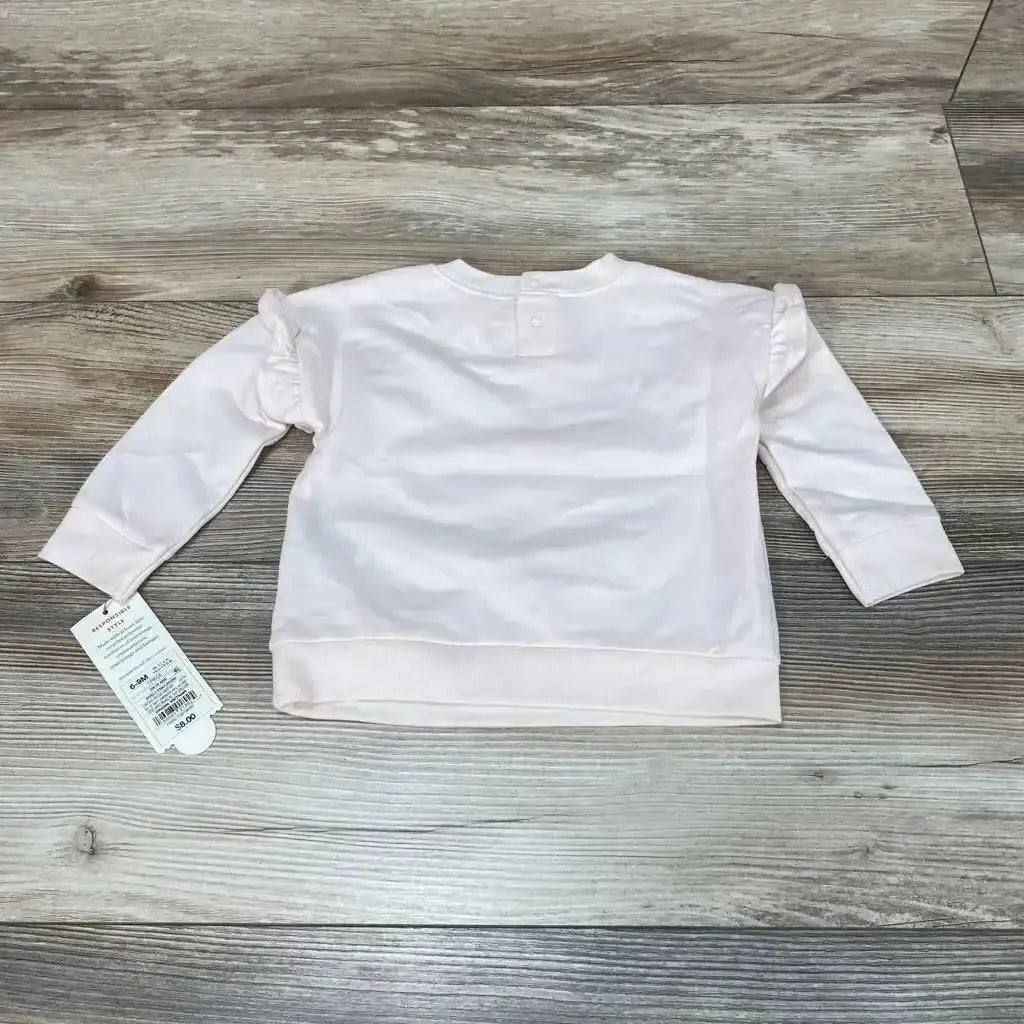 Front view of Cat and Jack Rainbow Sweatshirt sz 6-9m showcasing ruffled shoulders and button neckline on a wood-look floor