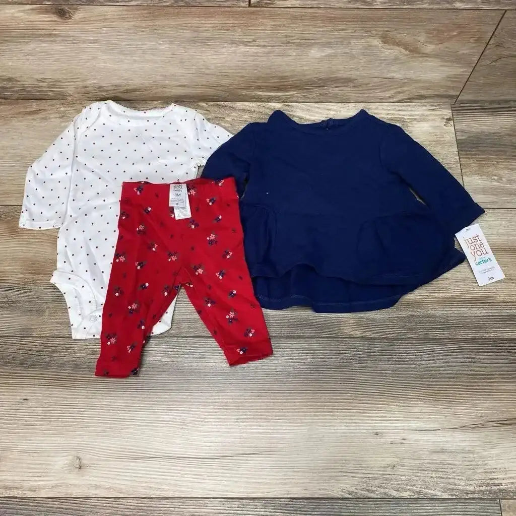 Flat lay of 3-piece baby outfit (3M): navy long-sleeve tunic, white polka-dot bodysuit, red floral pants on wood floor