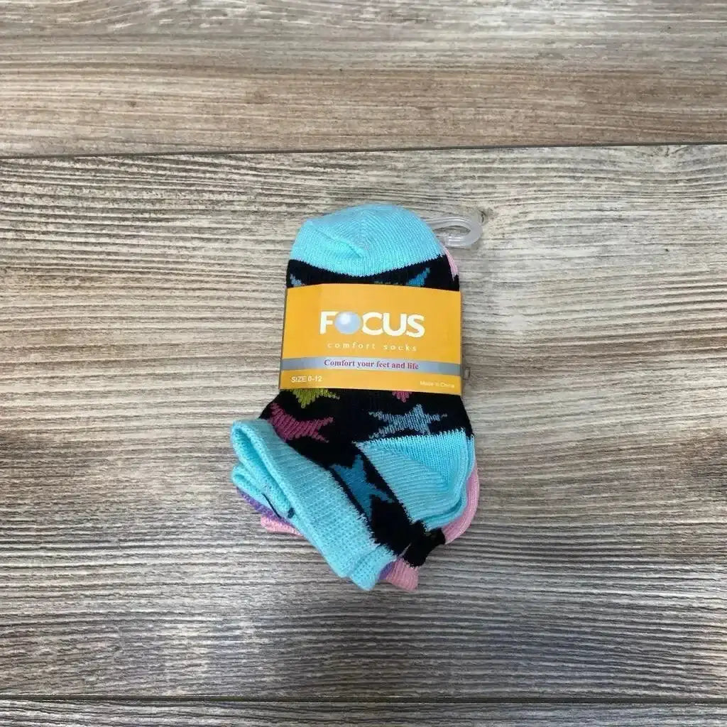 Top-down view of Focus 3-pack baby socks (0-12m) showcasing aqua and pink stars with yellow Focus label on wood background