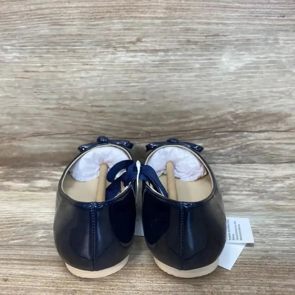 Rear view of Janie & Jack navy patent bow ballet flats size 9C showing glossy finish and decorative bows on a wood surface