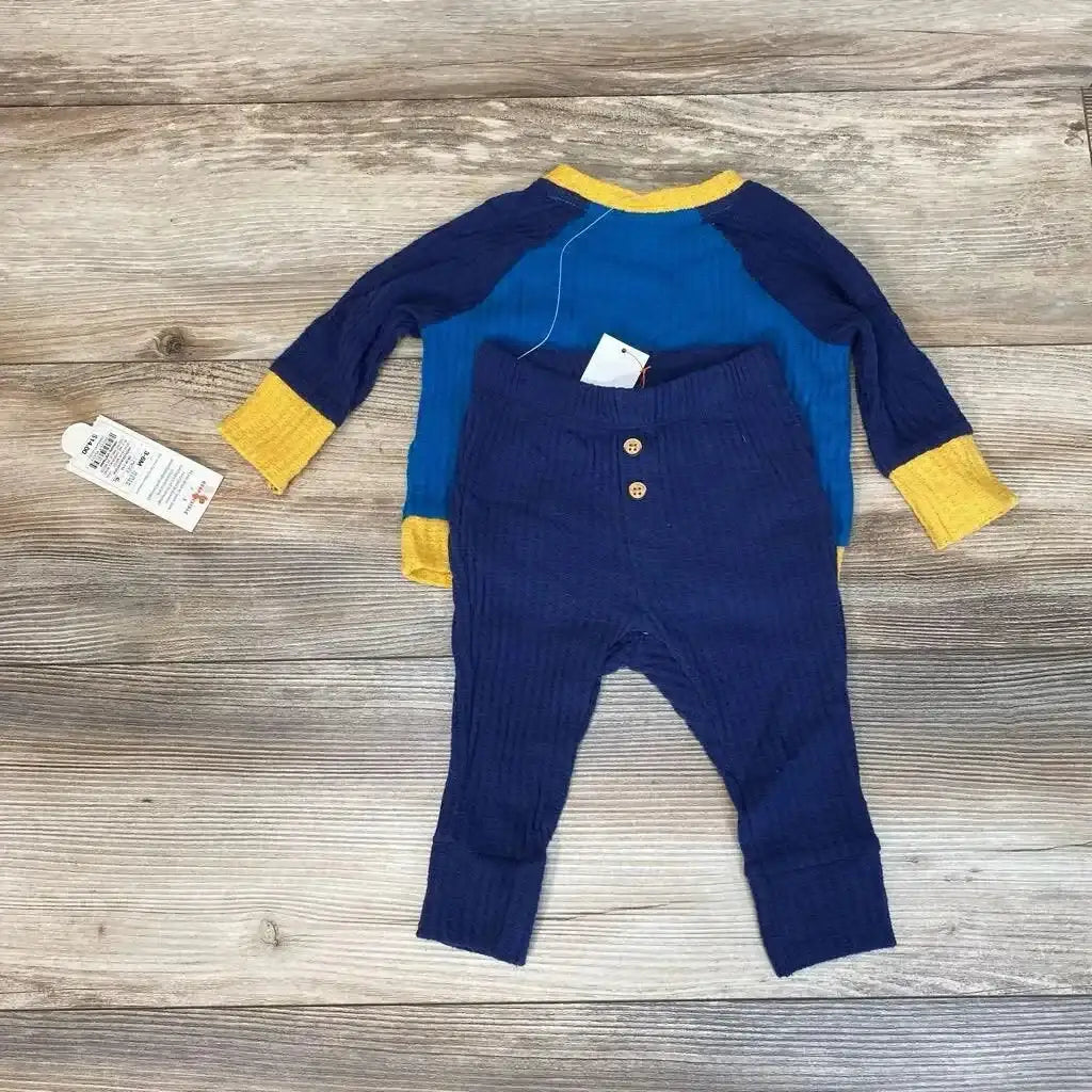 Flat lay of Cat & Jack blue waffle-knit long-sleeve shirt and navy waffle-knit pants showing yellow cuffs and ribbed texture on wood background