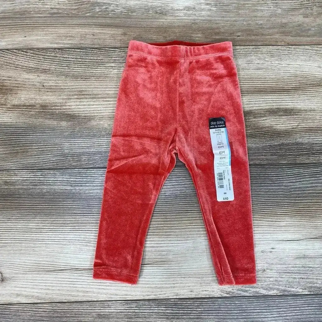 Front view of NEW Okie Dokie velour leggings in size 6M showcasing red velour fabric on a wood-grain background