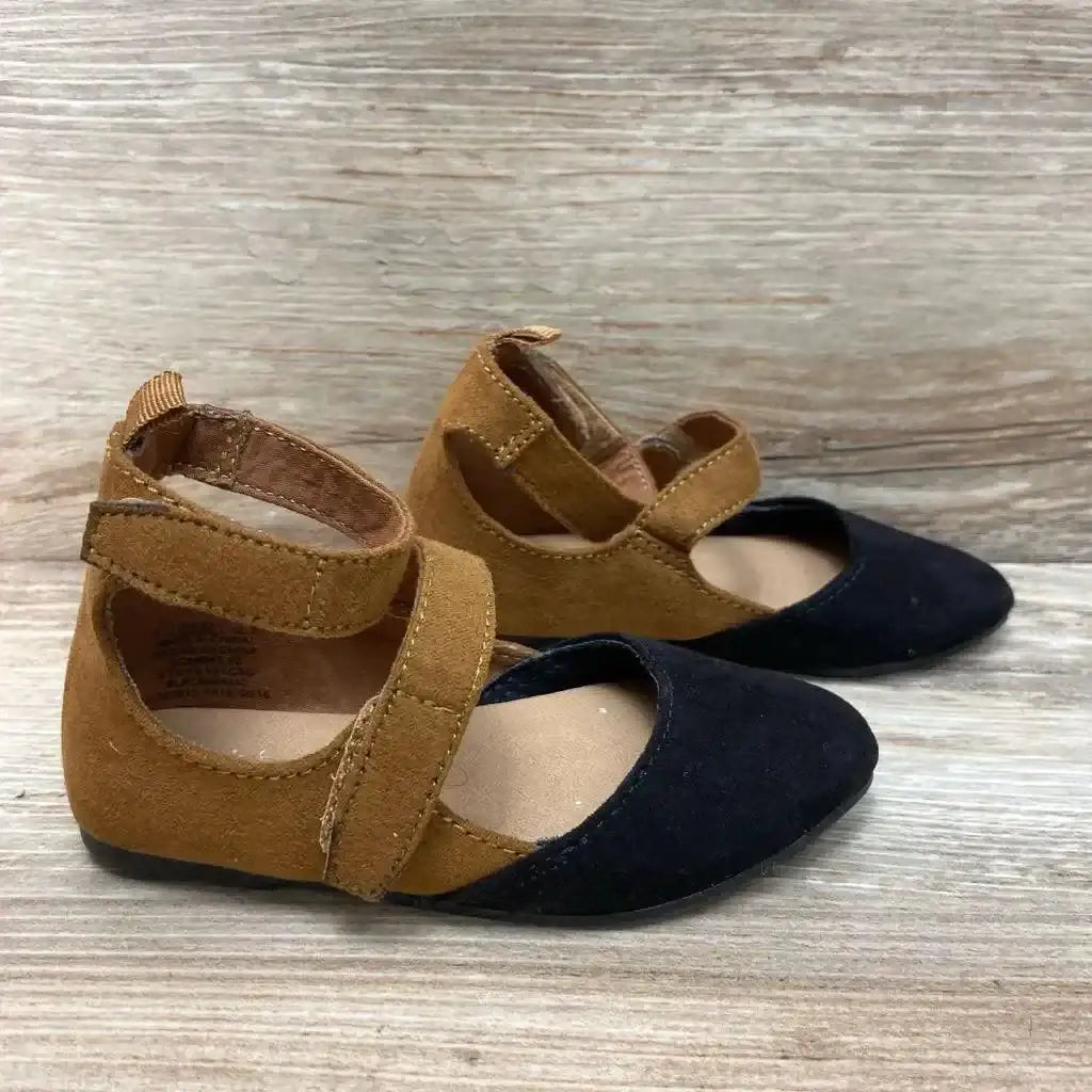 Side view of toddler ballet flats showing brown suede body, black toe cap, and Velcro ankle strap on light wood background