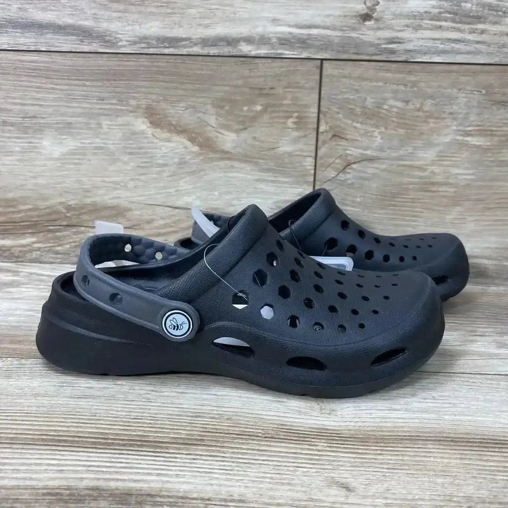 Side view of black Joybees unisex varsity clogs, size 2Y, showing vented upper and heel strap on wooden floor