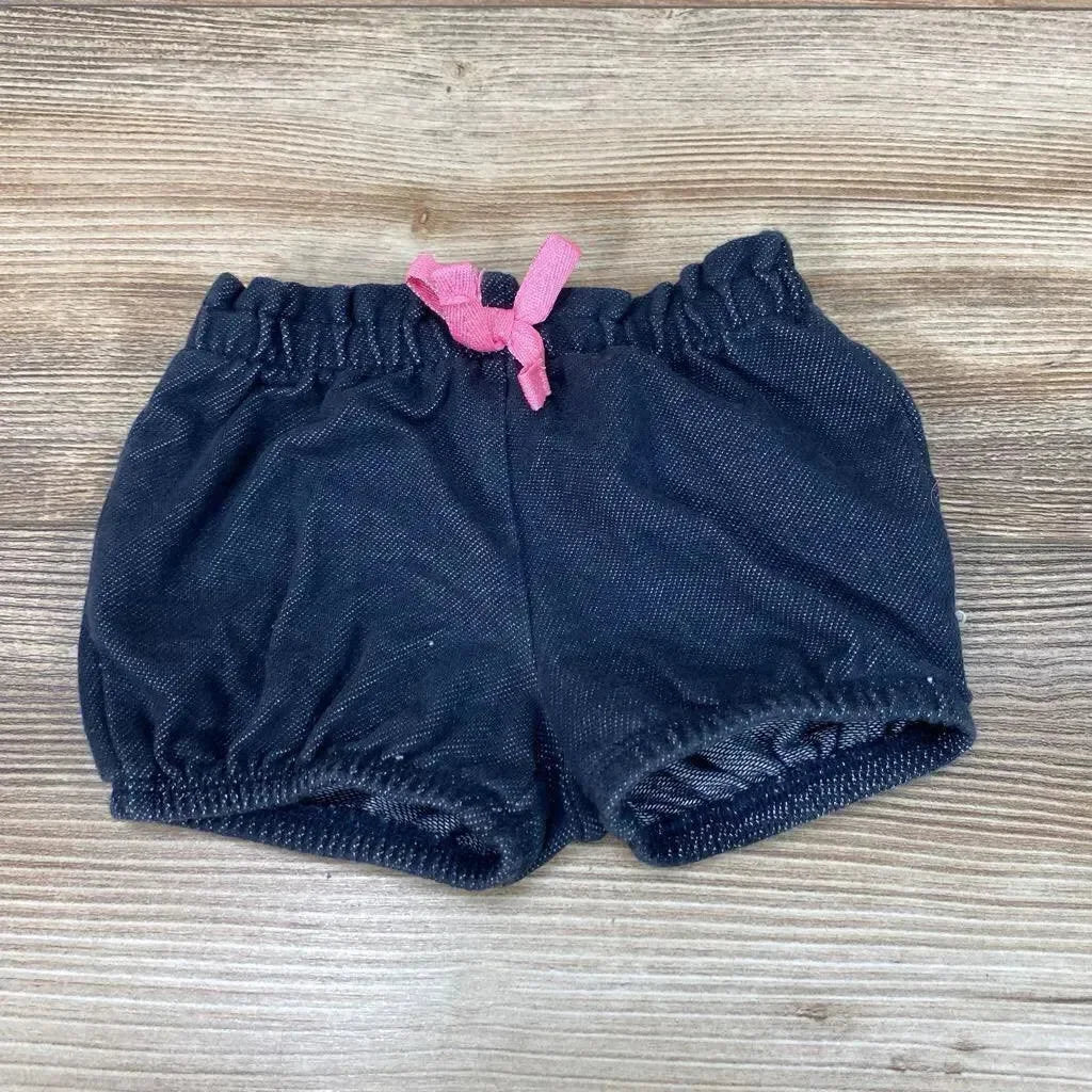 Top view of Jumping Beans navy baby shorts, 3 months, showing elastic waistband and pink drawstring bow on wood background