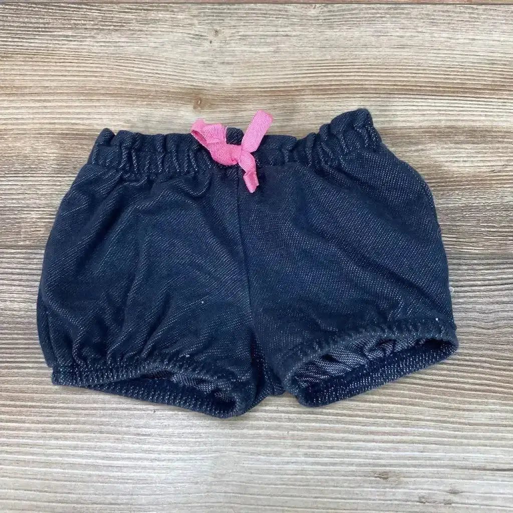 Top view of Jumping Beans navy baby shorts, 3 months, showing elastic waistband and pink drawstring bow on wood background