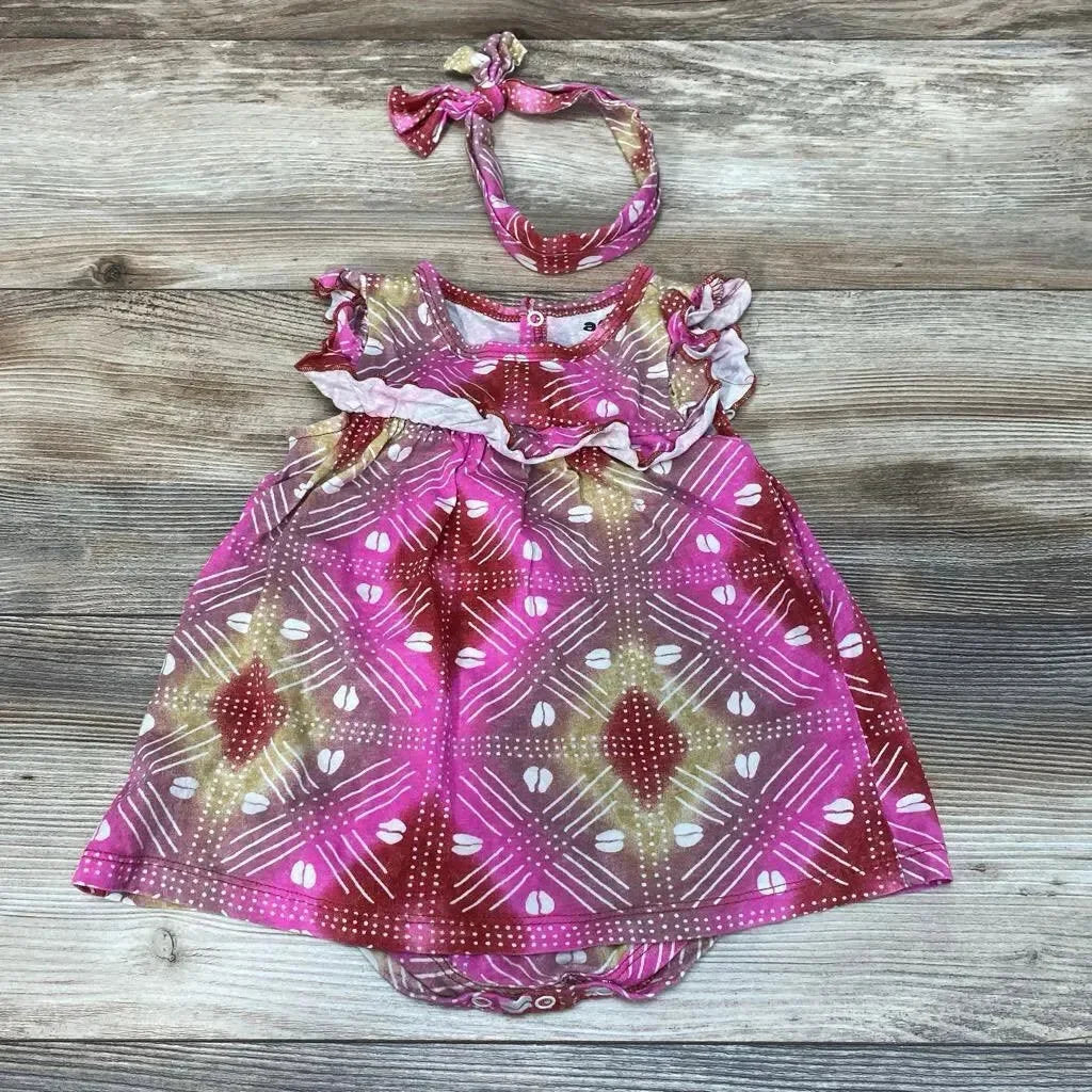Flat lay of pink patterned 2-piece baby bodysuit dress size 6-9 months with ruffle sleeves and matching headband on wood background