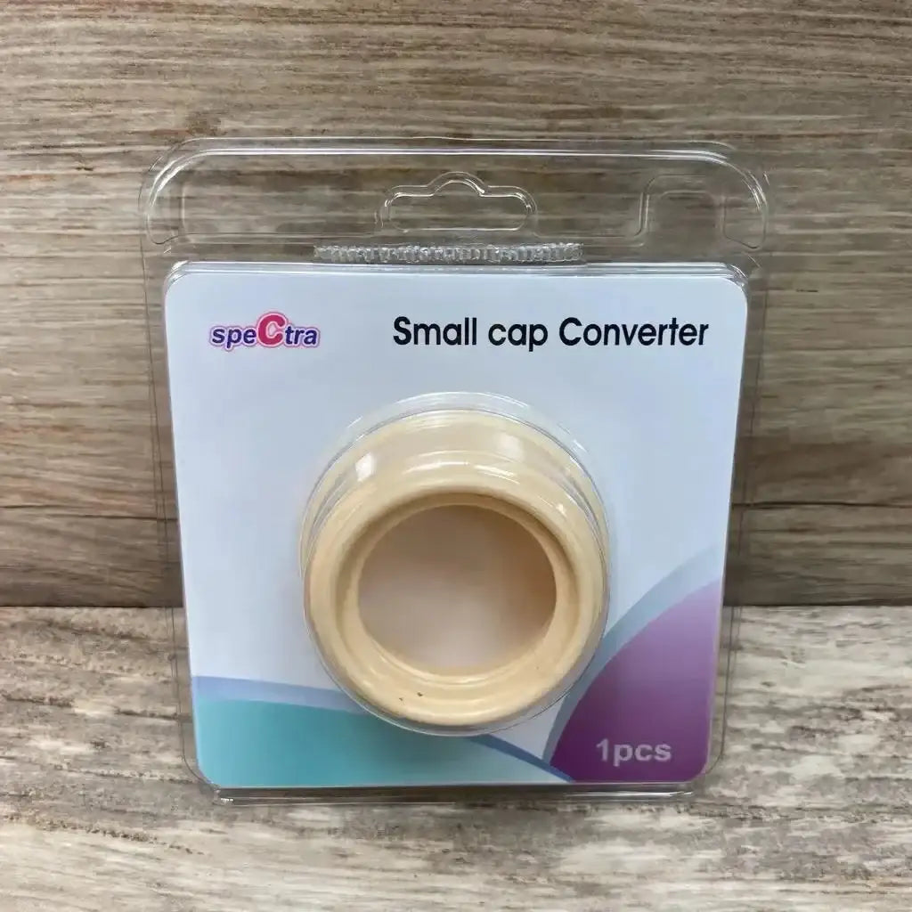 Front view of Spectra small-to-wide bottle cap adapter in blister pack showing Small cap Converter text on wood background
