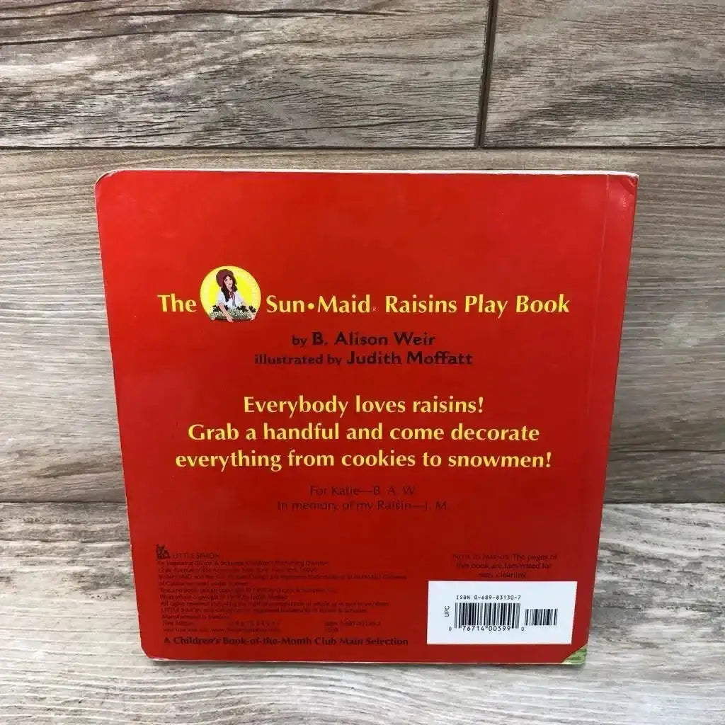 Back cover of Sun-Maid Raisins Play board book showing red cover with yellow title text, promotional blurb, and barcode on a wood background