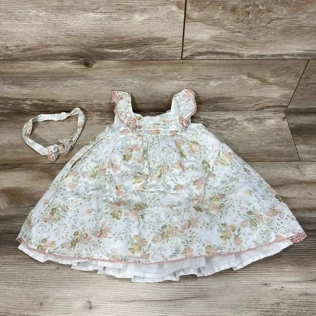 Flat lay of Cupcakes and Cashmere 3T floral dress and headband with ruffle straps and layered skirt on wood floor