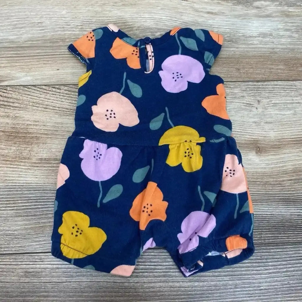 Flat lay of Just One You Floral Romper sz Newborn showcasing navy background with pink orange yellow and purple poppy print on wood plank background
