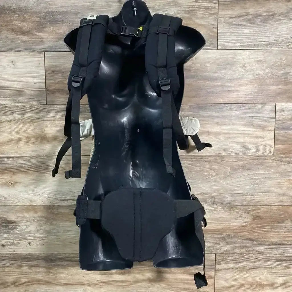 Back view of LILLEbaby 6-Position Complete Airflow Baby Carrier in black with padded shoulder straps and waist belt on black torso mannequin on wood plank floor