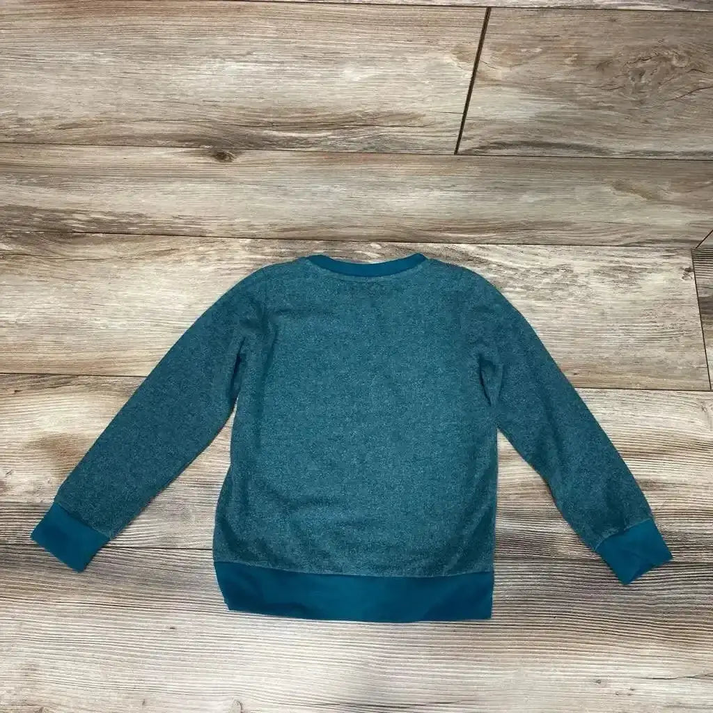 Back view of green Sol Angeles toddler pullover 4T showing crew neck, long sleeves, and darker teal ribbed cuffs and hem on wood floor