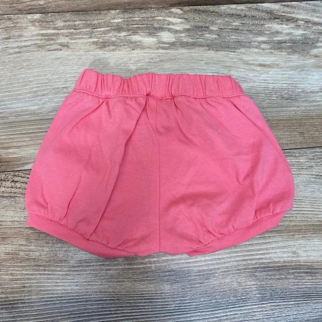 Flat-lay of pink Okie Dokie bubble shorts size 3M showcasing elastic gathered waistband and bubble hem on wood background