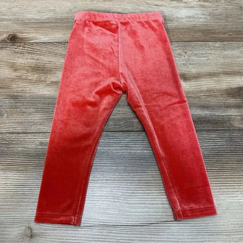 Flat-lay front of red velour Okie Dokie baby leggings showing elastic waistband and full-length legs on light wood background