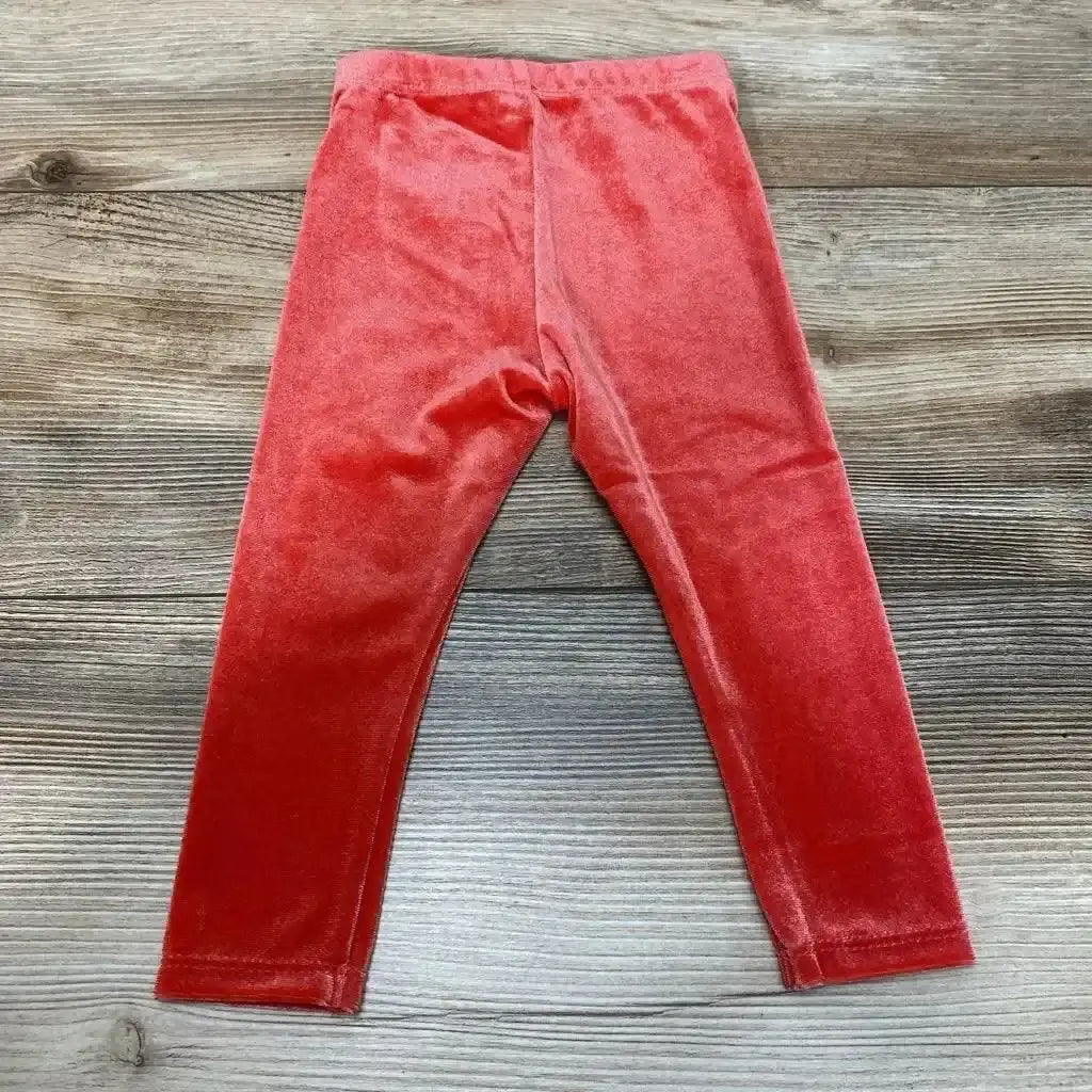 Flat-lay front of red velour Okie Dokie baby leggings showing elastic waistband and full-length legs on light wood background