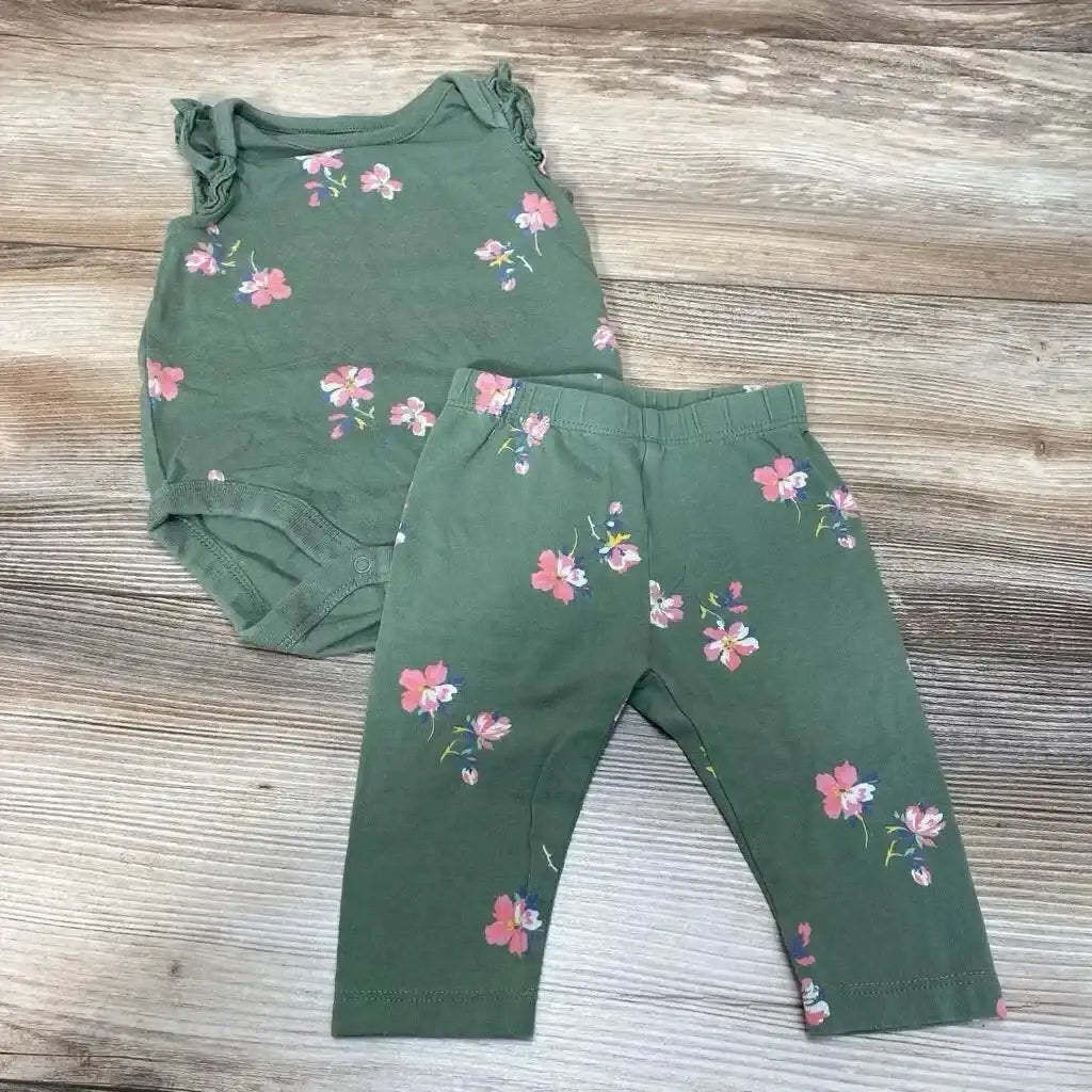 Flat lay of green BabyGap 2-piece bodysuit and leggings, size 0-3M, pink floral print and ruffled sleeves on wood background