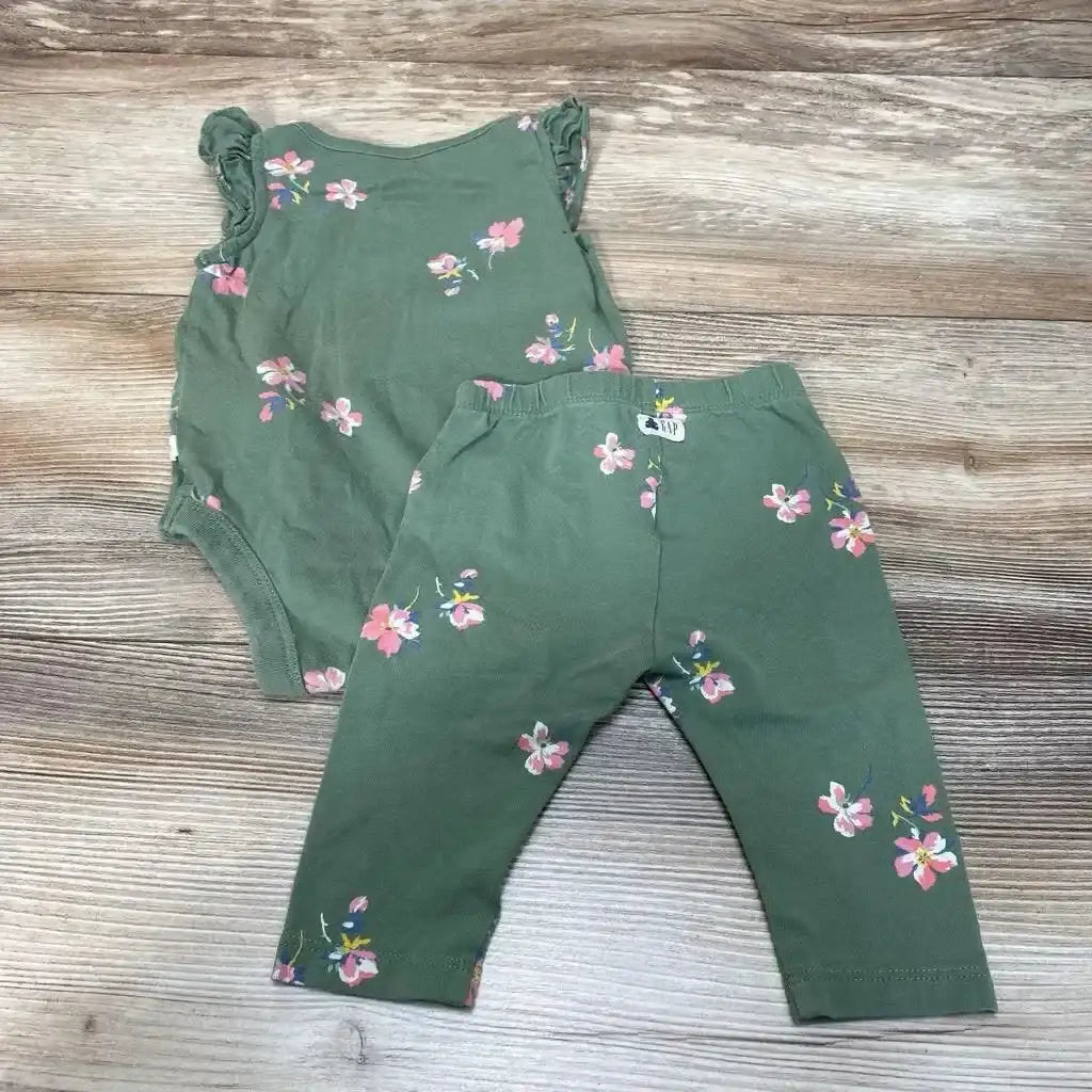 Top view of BabyGap green 2-piece floral bodysuit and leggings showing ruffle sleeves and elastic waist on wood background