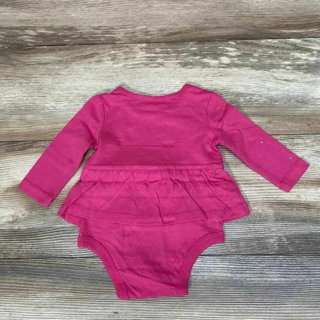 Front view of NEW Okie Dokie skirted bodysuit in size 3m showcasing long sleeves and attached skirt on a wood-grain background