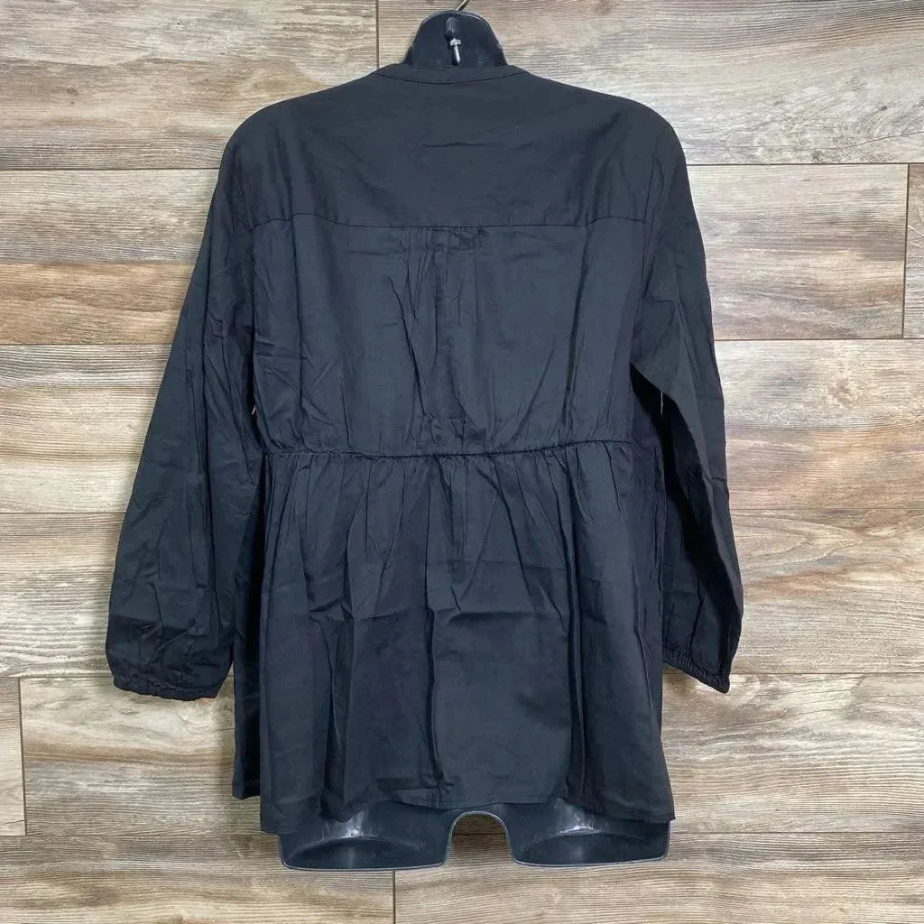 Back view of black maternity button-front woven top showing gathered waist and long sleeves on hanger against wood background