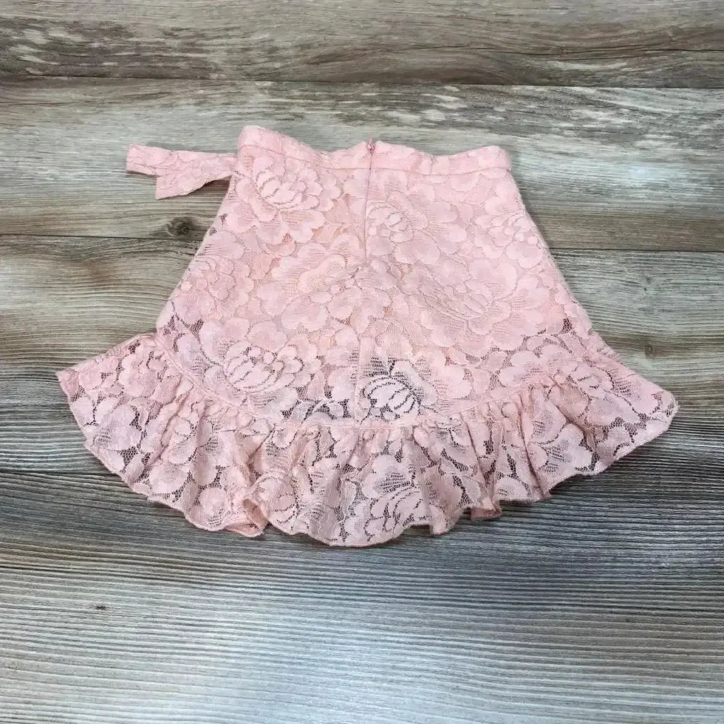 Top view of Bailey’s Blossoms Lace Skirt sz 12-18M in pink showcasing floral lace and ruffled hem on a gray wood surface