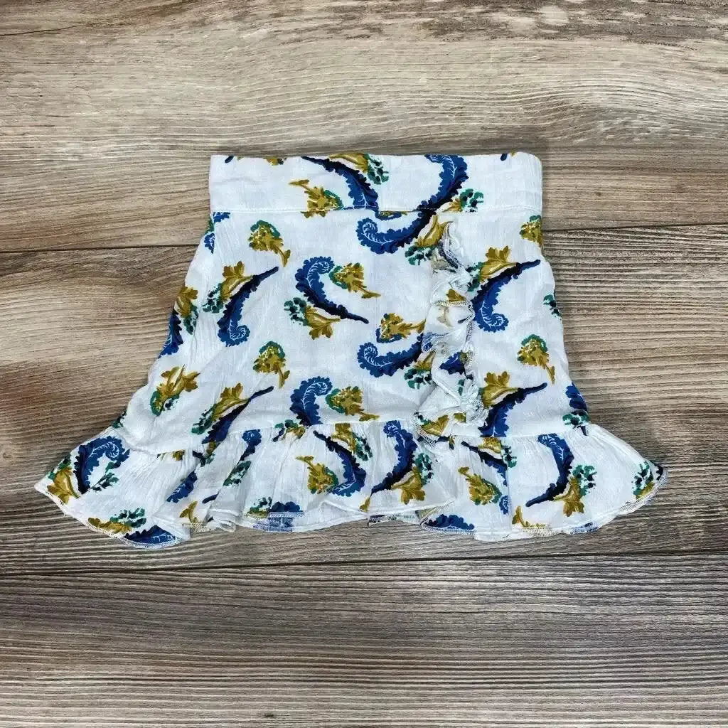 Front view of Bailey’s Blossoms Ruffle Skirt sz 0-3M showcasing its ruffled hem and blue and mustard print on a wood-grain background